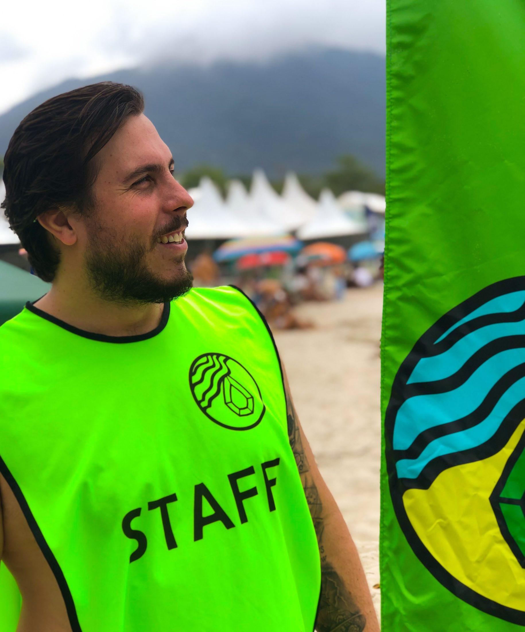 Voluntário da Esmeralda ao lado da bandeira na praia