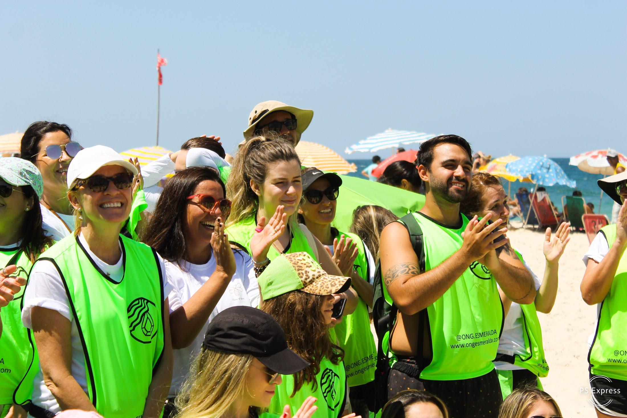 Voluntários da Onda Verde aplaudindo na praia