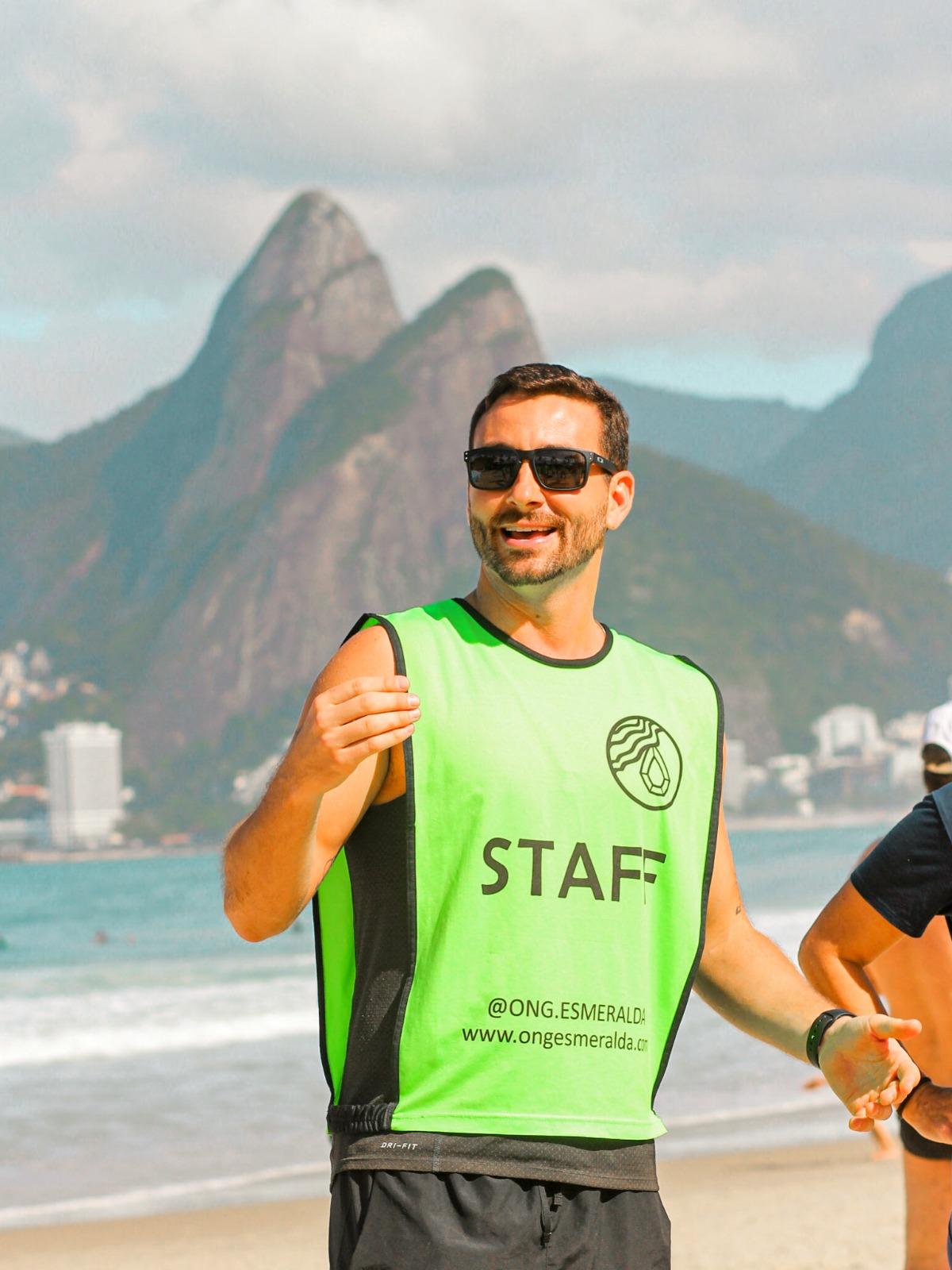 Voluntário da Esmeralda na praia, com os Dois Irmãos ao fundo