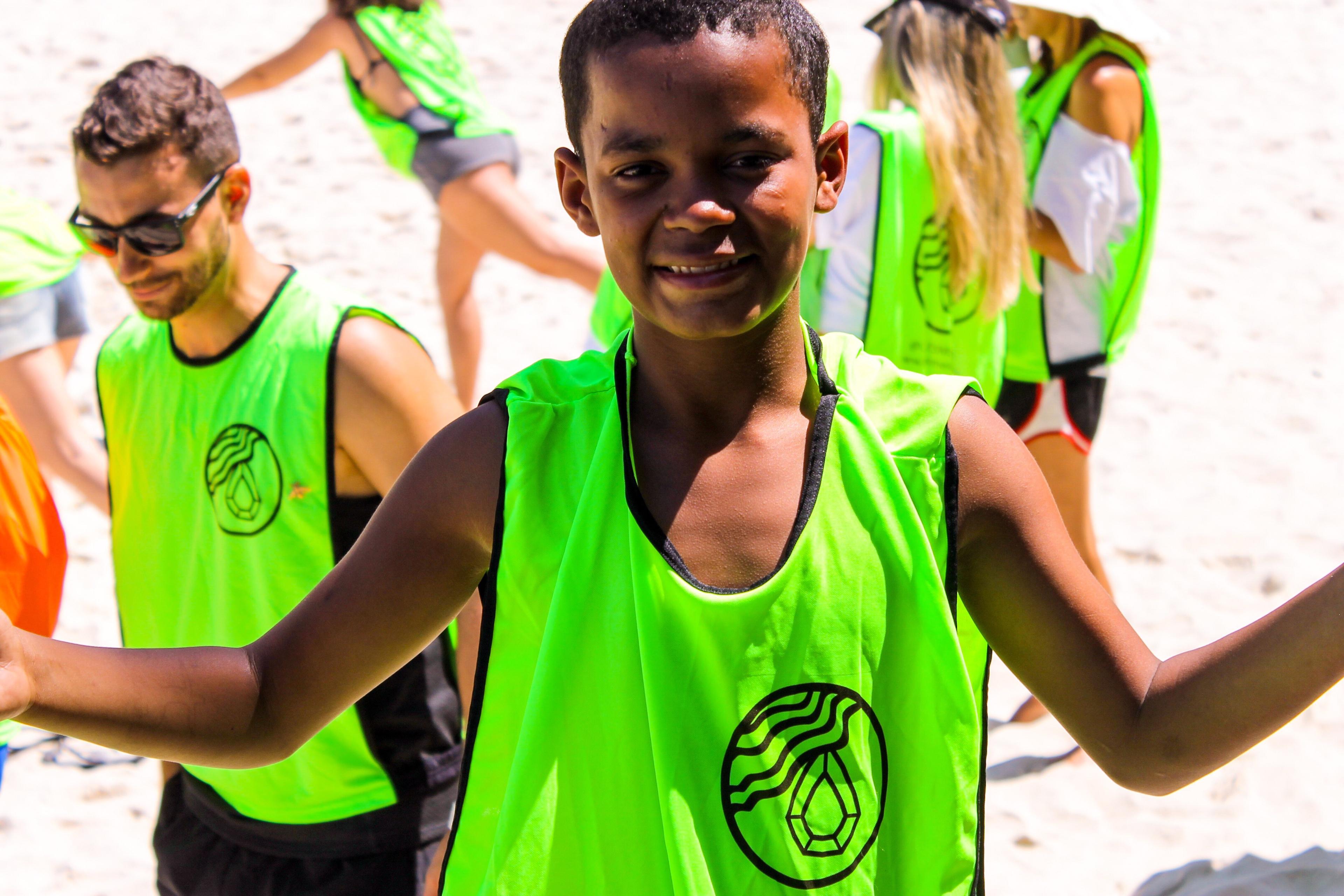 Voluntário mirim da Esmeralda de colete na praia